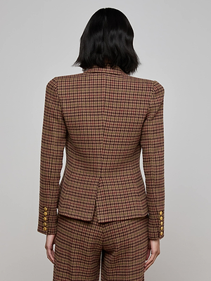 A person with shoulder-length dark hair is seen from behind, wearing the L'AGENCE Bethany Houndstooth Blazer, featuring lion head sleeve buttons, posed against a plain light gray background.