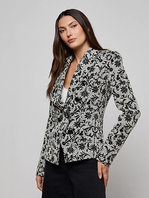 A woman with long brown hair models the Bethany Flocked Tweed Blazer over a white top and black pants, posing against a plain light grey background.