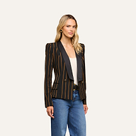A woman stands facing forward, wearing the Imogen Satin Lapel Blazer—featuring yellow vertical stripes—over a white top and blue jeans, against a plain light background.