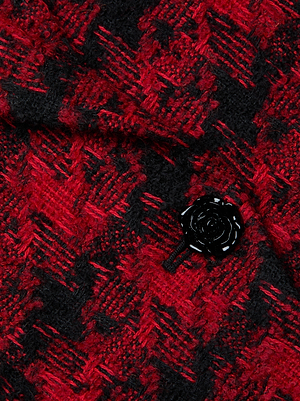 Close-up of the L'AGENCE Kaisley Tweed Blazer in red and black houndstooth Italian tweed, detailed with a shiny black rose-shaped button.