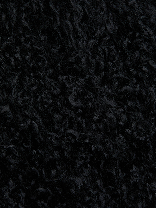 Close-up of the Aura Cropped Faux Fur Jacket by L'AGENCE, showing its curly, densely packed wavy strands that give a plush, wool-like appearance and luxuriously soft feel.