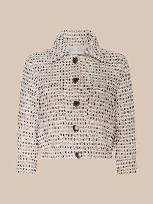 The Jia Cropped Tweed Jacket is a chic cream and black textured tweed piece with a collared neckline, long sleeves, and five dark heart-shaped buttons, shown here against a plain beige background.