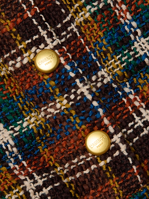 Close-up of the Jia Cropped Tweed Jacket, crafted in multicolored bouclé tweed with a plaid pattern. Features two gold “KASSL EDITIONS” buttons and a rich blend of brown, green, blue, yellow, and white for standout texture.