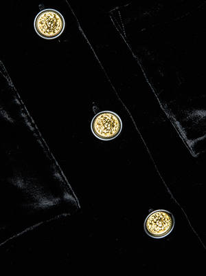 Close-up of the L'AGENCE Jia Velvet Jacket, showcasing three ornate gold buttons arranged vertically on the rich black velvet fabric.