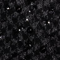 Black tweed fabric of a Jia Sequined Tweed Jacket with a cropped silhouette, textured knit pattern, and scattered black sequin embellishments.