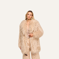 Wearing the Toira Faux Fur Coat over a coordinated beige ensemble with sequin-embellished pants, this individual stands against a plain, light background, effortlessly channeling a vintage-inspired 70s rockstar vibe.
