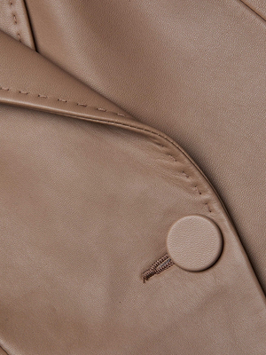 Close-up of the Vashti Fringed Leather Blazer in light brown Italian lambskin, featuring a matching round button and visible stitching, highlighting its smooth texture and layered folds.