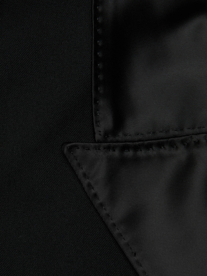 Close-up of the L'AGENCE Hollis Vest in black, highlighting the smooth satin lapel and intricate edge stitching with a refined satin finish.