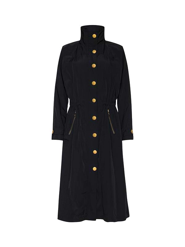 The Toshi Windbreaker is a long black water-repellant coat with a high collar, gold buttons, zippered side pockets, cuff buttons, and classic trench silhouette.