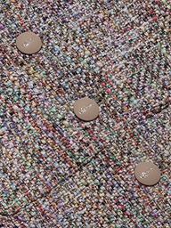 Close-up of the Chita Tweed Jacket’s multi-colored tweed fabric, featuring three beige buttons engraved with ‘MAJE’. The textured threads—shades of purple, green, yellow, and red—create a vibrant woven pattern that highlights the jacket’s distinctive cropped style.