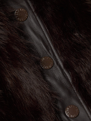 Close-up of the Claira Faux Fur Jacket by L'AGENCE, showcasing long hair faux fur, leather trim, and four round buttons with subtle raised text—an essential for cold weather style.