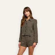 A woman wearing a black and gold wool-blend tweed Marla Cropped Jacket with matching shorts.