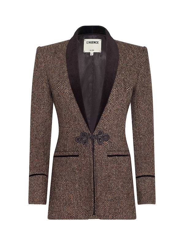 The Gable Herringbone Blazer by L’AGENCE is a tailored brown blazer made from Italian recycled wool, featuring a black velvet shawl lapel, decorative front clasps, and two front pockets.