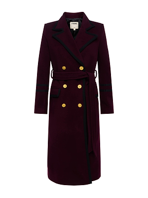 The Irene Long Coat by L'AGENCE is a deep maroon double-breasted women’s coat made from Italian recycled wool, featuring gold buttons, black trim, a matching belt, notched lapel, and two front pockets.