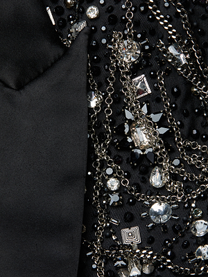 Close-up of the Soma Embellished Blazer: black fabric detailed with silver chain fringe and hand-embellished crystals, shown next to a smooth black satin lapel.