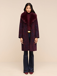 A model wears a long patterned coat with a dark burgundy faux fur collar over a matching sweater and dark Marty Coated Flare Jean.