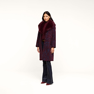 A woman stands against a plain white background, wearing the Laney Jacquard Coat—a long, vintage-inspired coat featuring a large faux fur collar—paired with dark pants and burgundy shoes.