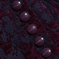Five round, glossy, dark purple buttons embossed with “LAGENCE” sit atop the textured, burgundy and navy jacquard fabric of the Laney Jacquard Coat, evoking vintage-inspired outerwear.
