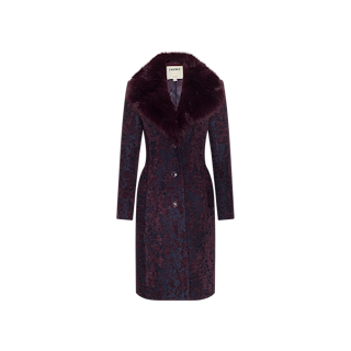 The Laney Jacquard Coat is a long, dark plum outerwear piece featuring an intricate textured pattern and a wide, plush faux fur collar. Vintage-inspired and tailored with front buttons, it is finished with a label at the neck. Shown against a plain white background.
