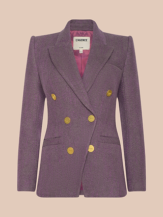 The Kyomi Double-Breasted Blazer, featuring a tailored purple herringbone design with gold buttons, notched lapels, and front pockets, is displayed on a light peach background.