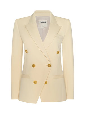 The Kyomi Double-Breasted Blazer is a cream-colored, tailored piece with gold buttons, two front pockets, pointed lapels, and a sleek fit. The inner collar is labeled LAGENCE.
