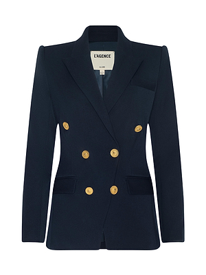 The Kyomi Double-Breasted Blazer by L'AGENCE is navy blue with gold buttons, peaked lapels, and two side flap pockets. The label inside the collar reads L'AGENCE.