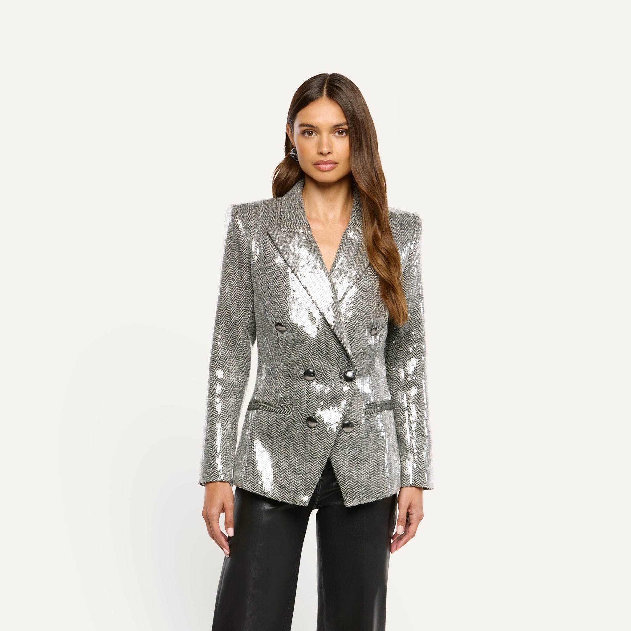 A woman wearing a Kyomi Sequined Blazer in silver paired with black trousers.