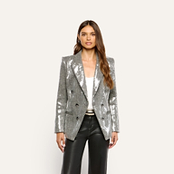 A woman wearing a Kyomi Sequined Blazer in silver over a white top and black trousers.