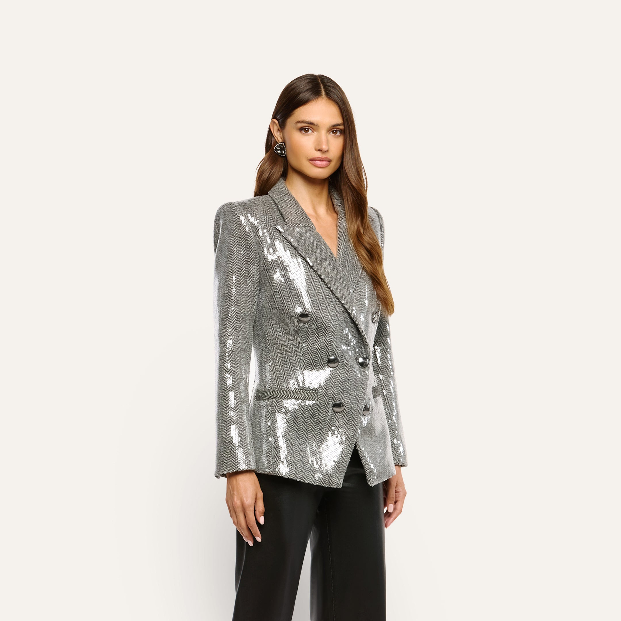 A woman wears a Kyomi Sequined Blazer, a double-breasted, silver sequin jacket with black buttons.