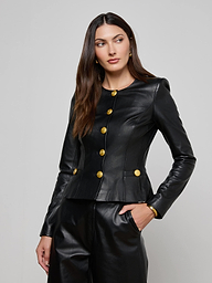 A woman stands against a plain light background with one hand in her pocket, wearing the Mariella Leather Jacket—a fitted black lambskin piece featuring large gold buttons—paired with matching leather pants.