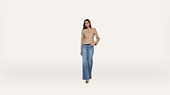 Woman wearing a tan button-up jacket and blue wide-leg jeans stands against a plain white background. She has one hand in her pocket and looks confidently at the camera.