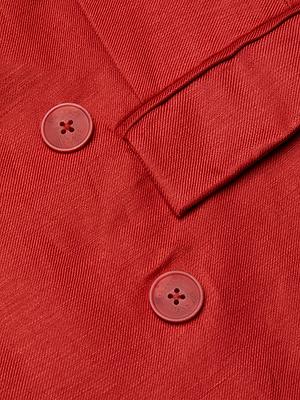 Close-up of the Cambrie Oversized Blazer in red linen, featuring two red plastic buttons and part of a stitched flap. The diagonal weave gives this statement blazer a refined, textured look.