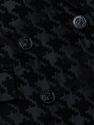 Close-up of the Cambrie Oversized Houndstooth Blazer's black houndstooth fabric, featuring two rows of four embossed black buttons on its textured material.