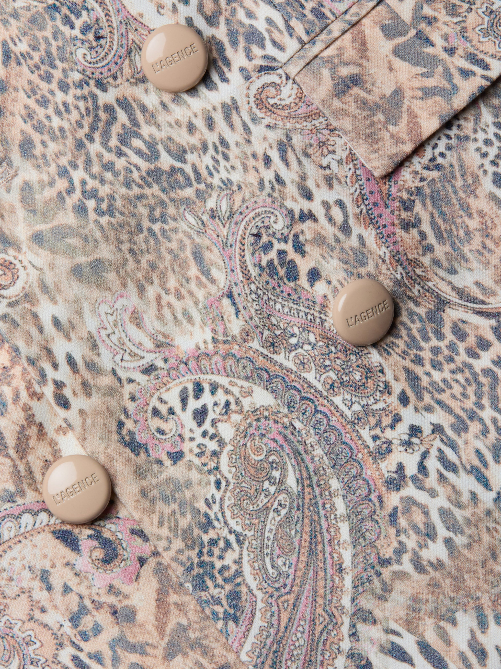 Gros plan sur le blazer Cambrie Oversized Linen-Blend Blazer en paisley léopard beige, marron et rose, avec quatre boutons en relief CARGENIC beige.