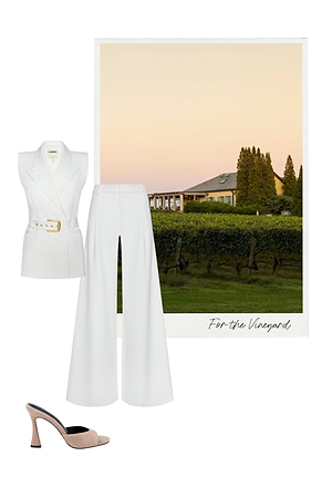 A sleeveless white belted blazer, white wide-leg pants, and blush open-toe heels are styled beside a photo of a vineyard at sunset with a farmhouse and green grapevines. Text reads For the Vineyard.