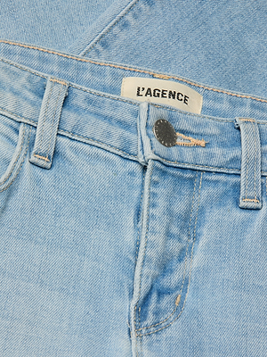 Close-up of Taney Low-Rise Flare Jean in light blue stretch denim, featuring the waistband, belt loops, metallic button, front pocket, and a fabric label with the LAGENCE brand name.