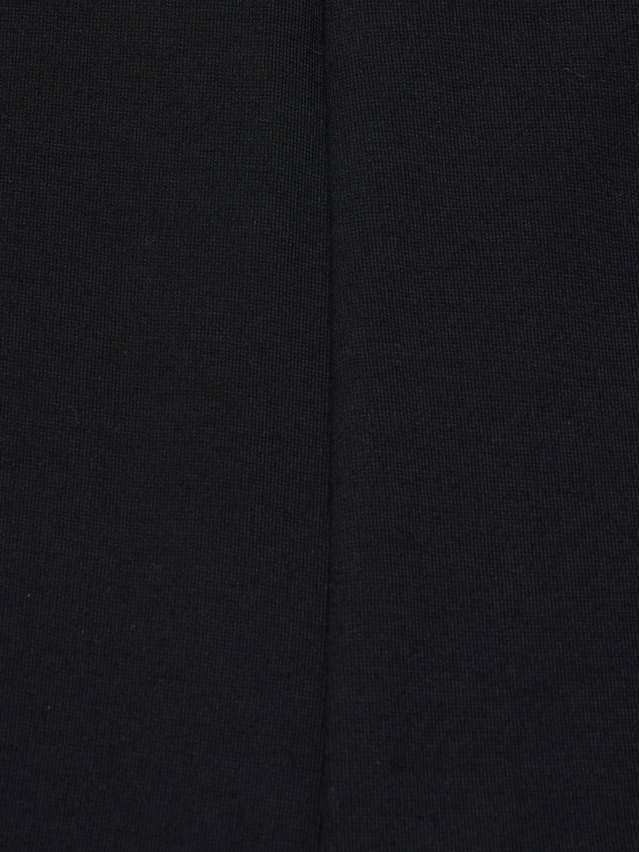 Close-up of the Dee Capri Pant in black stretch ponte fabric, highlighting a visible vertical seam down the center that showcases the material’s texture and stitching details for a flattering fit.