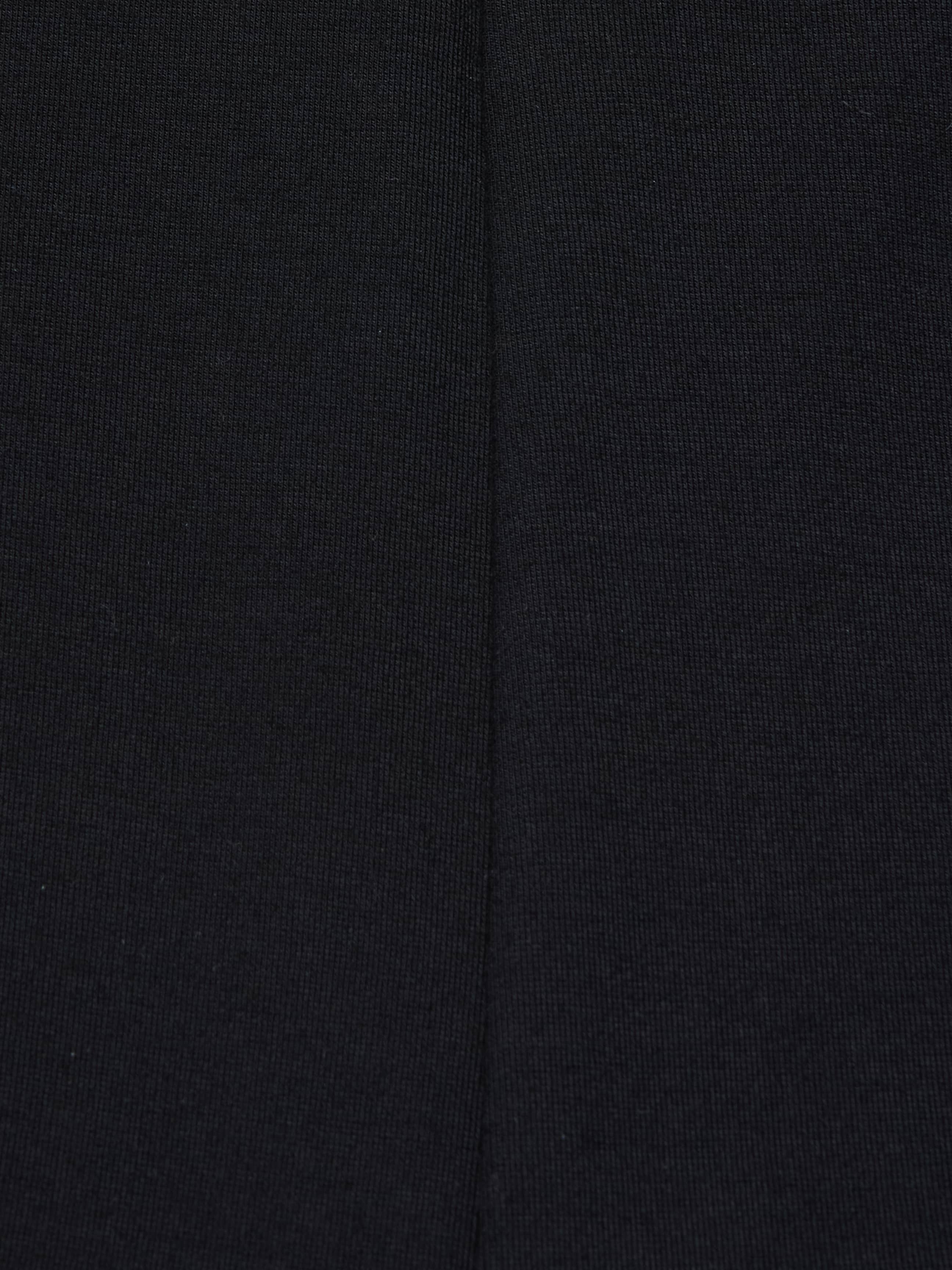Close-up of the Dee Capri Pant in black stretch ponte fabric, highlighting a visible vertical seam down the center that showcases the material’s texture and stitching details for a flattering fit.