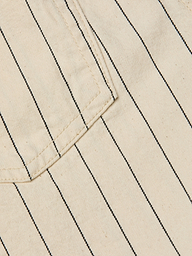 Close-up of the Lissania Short in beige, featuring thin vertical black pinstripes and visible stitching around the edge of a pocket.