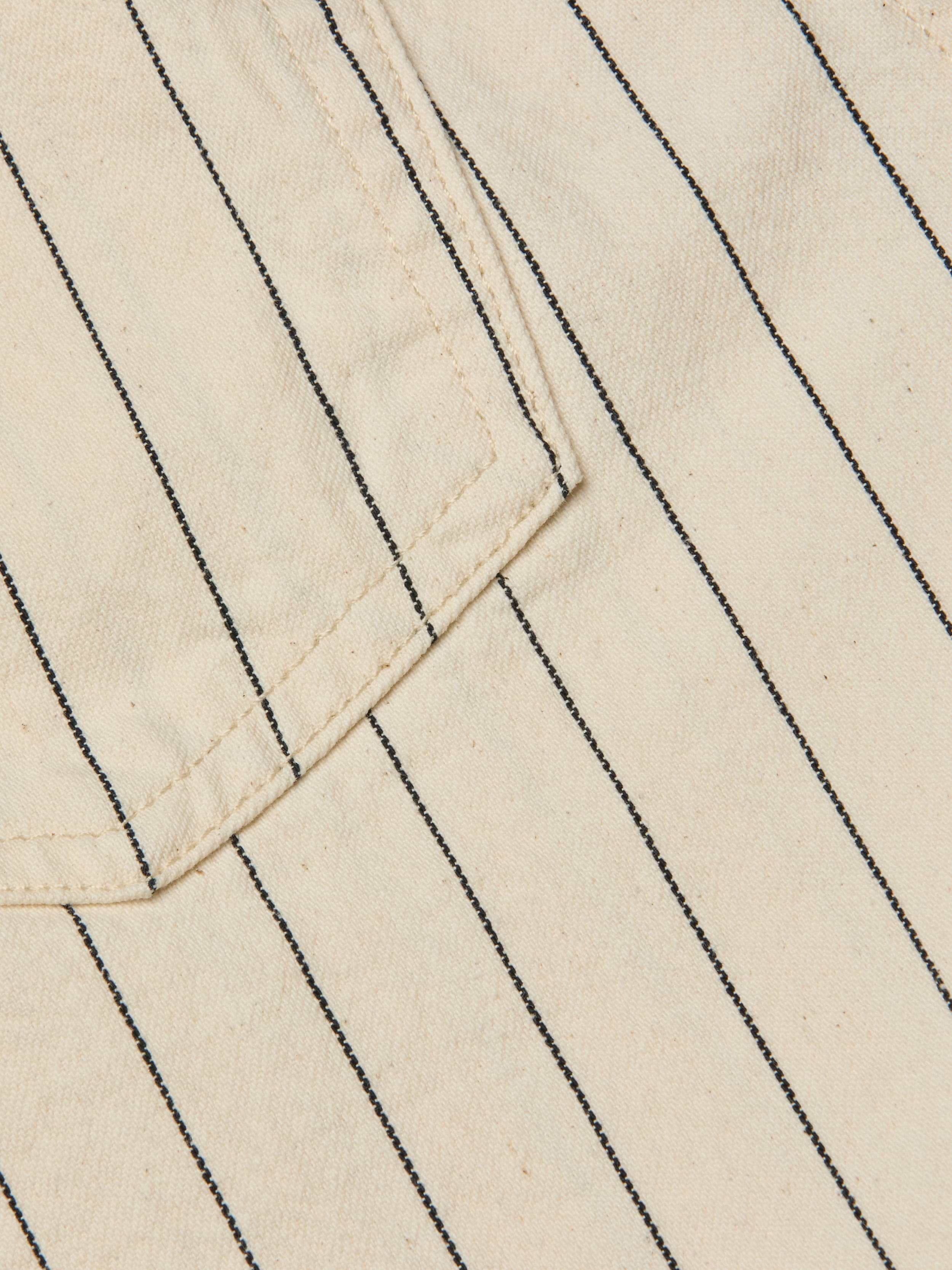 Close-up of the Lissania Short in beige, featuring thin vertical black pinstripes and visible stitching around the edge of a pocket.