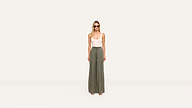 A woman stands against a plain white background, wearing sunglasses, a white sleeveless top, and high-waisted, wide-leg olive green pants for an effortlessly chic look.