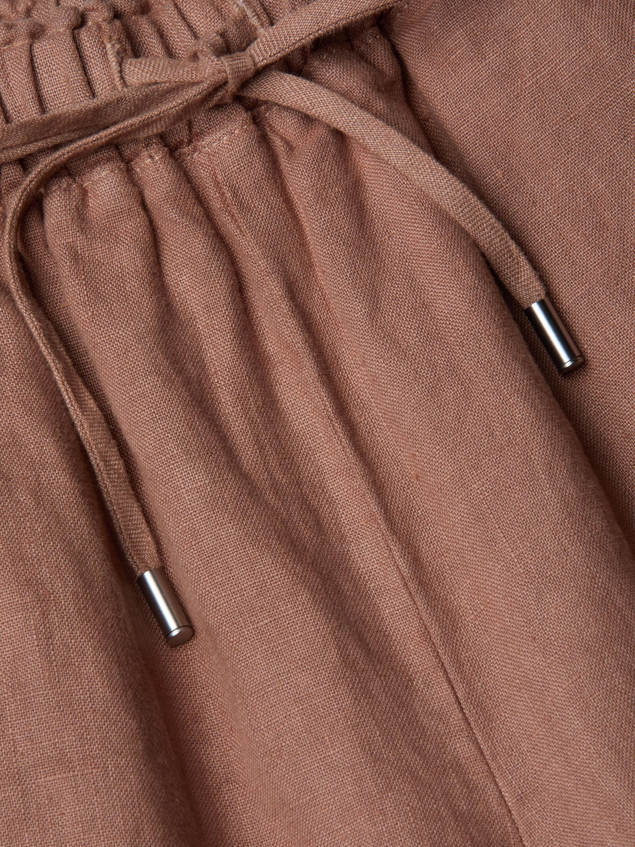 Close-up of the Connie Linen Drawstring Trouser in light brown, featuring a drawstring waistband with silver metal tips.