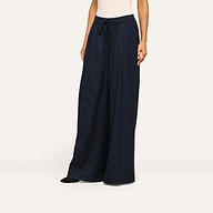 A person wearing the Connie Drawstring Trouser in navy blue, styled with a sleeveless, light-colored top, stands against a plain off-white background.