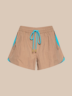 Il pantaloncino Grayson in nylon marrone chiaro è caratterizzato da nylon crepe idrorepellente, pannelli laterali blu brillante e coulisse blu abbinata, su uno sfondo beige semplice.