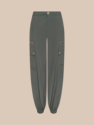 The Greer Nylon Jogger features an ash olive green color, zippered cargo pockets on the thighs, buttoned flaps, and elastic ankle cuffs in a modern jogger style, displayed against a light beige background.