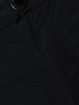 Close-up of Greer Nylon Jogger’s black fabric with visible seam and a black button at the top left, highlighting modern jogger details like possible cargo pockets for extra functionality.