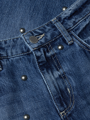 Close-up of the Bex Studded Rodeo Jean, featuring metallic studs, a buttoned waistband, detailed pocket stitching, and textured denim fabric.