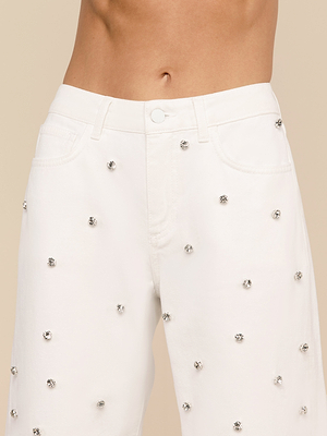 Primo piano di una persona che indossa il Bex Embellished Rodeo Jean, caratterizzato da un denim a vita alta con piccoli cristalli dargento rotondi sparsi sul tessuto e un ventre scoperto visibile.