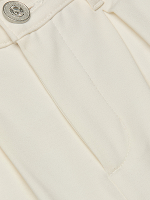 Close-up of a textured white fabric with a button detail