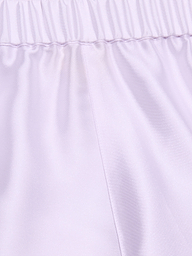 Close-up of the Maela Short in light purple, featuring a shiny poly twill fabric, an elastic waistband, and a visible vertical center seam—ideal for comfortable pull-on wear.